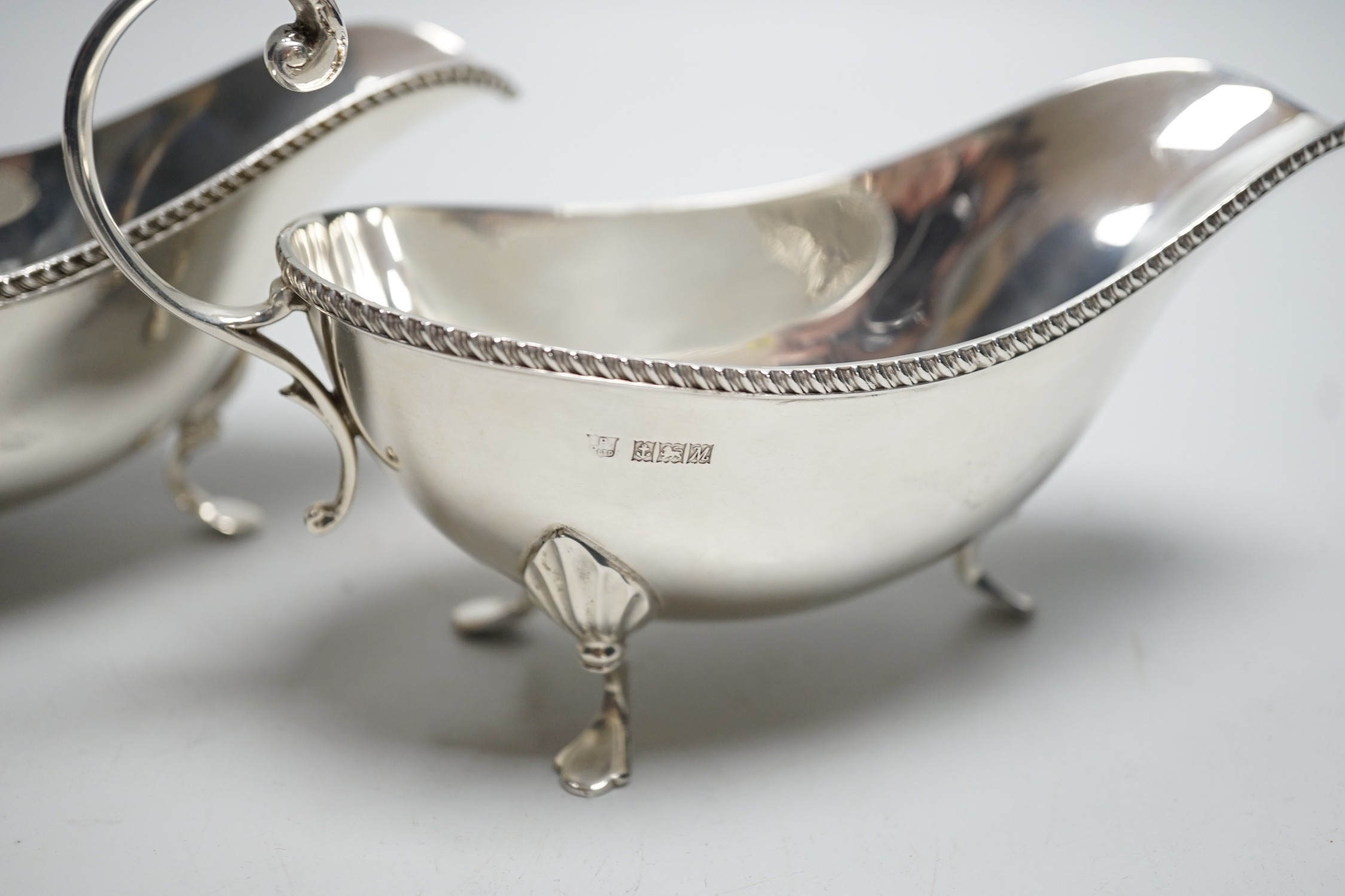 A pair of Elizabeth II silver sauce boats, with flying scroll handles, Poston Products Ltd, Birmingham, 1961, length 18cm, 11.3oz.